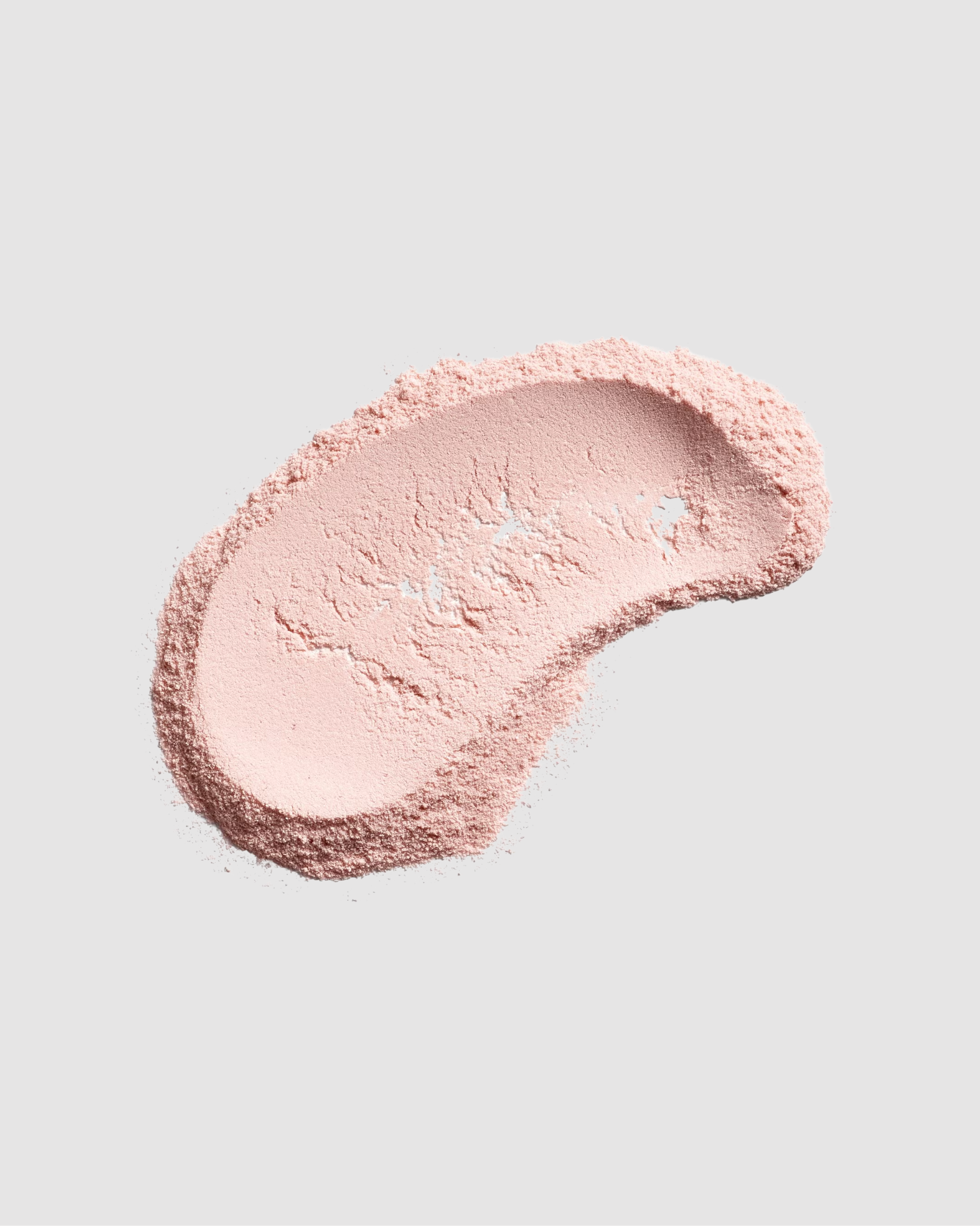 Pink cosmetic cream swatch on a light gray background