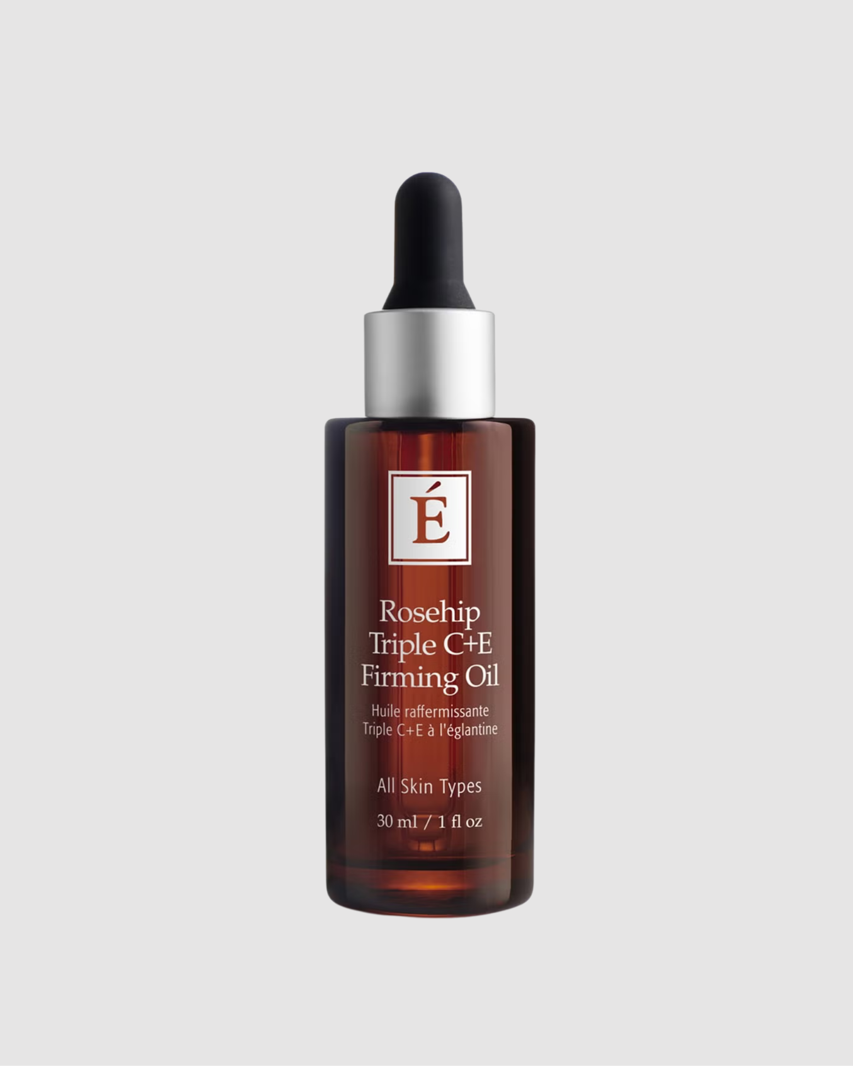 Bottle of Rosehip Triple C+E Firming Oil with a dropper on a light gray background