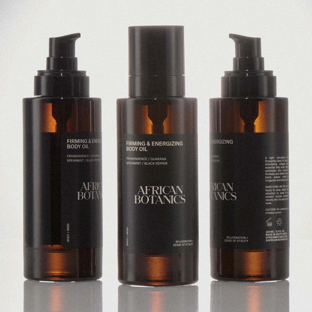 Three bottles of African Botanics Firming & Energizing Body Oil on a white background
