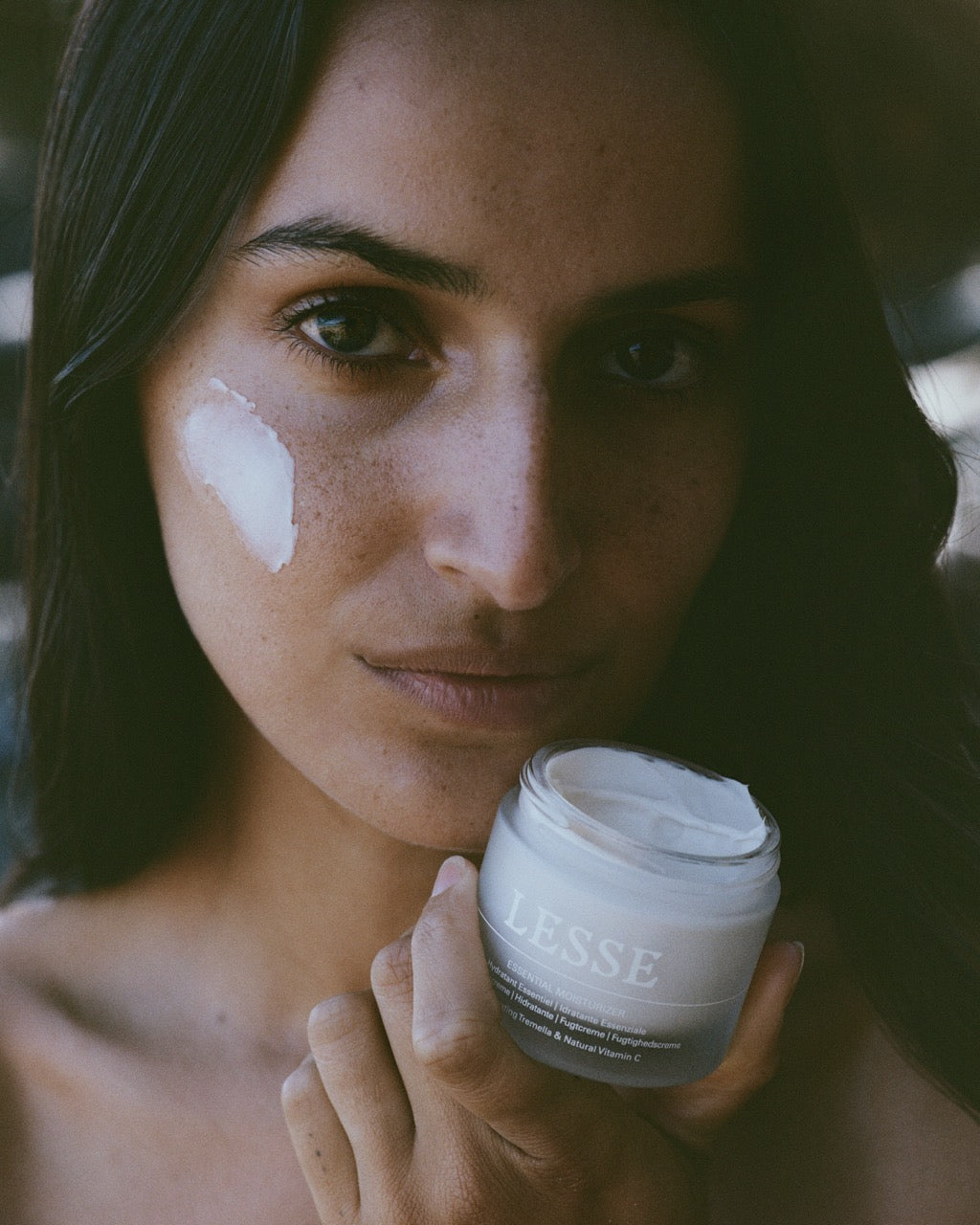 Woman holding a jar of cream with a blurred background