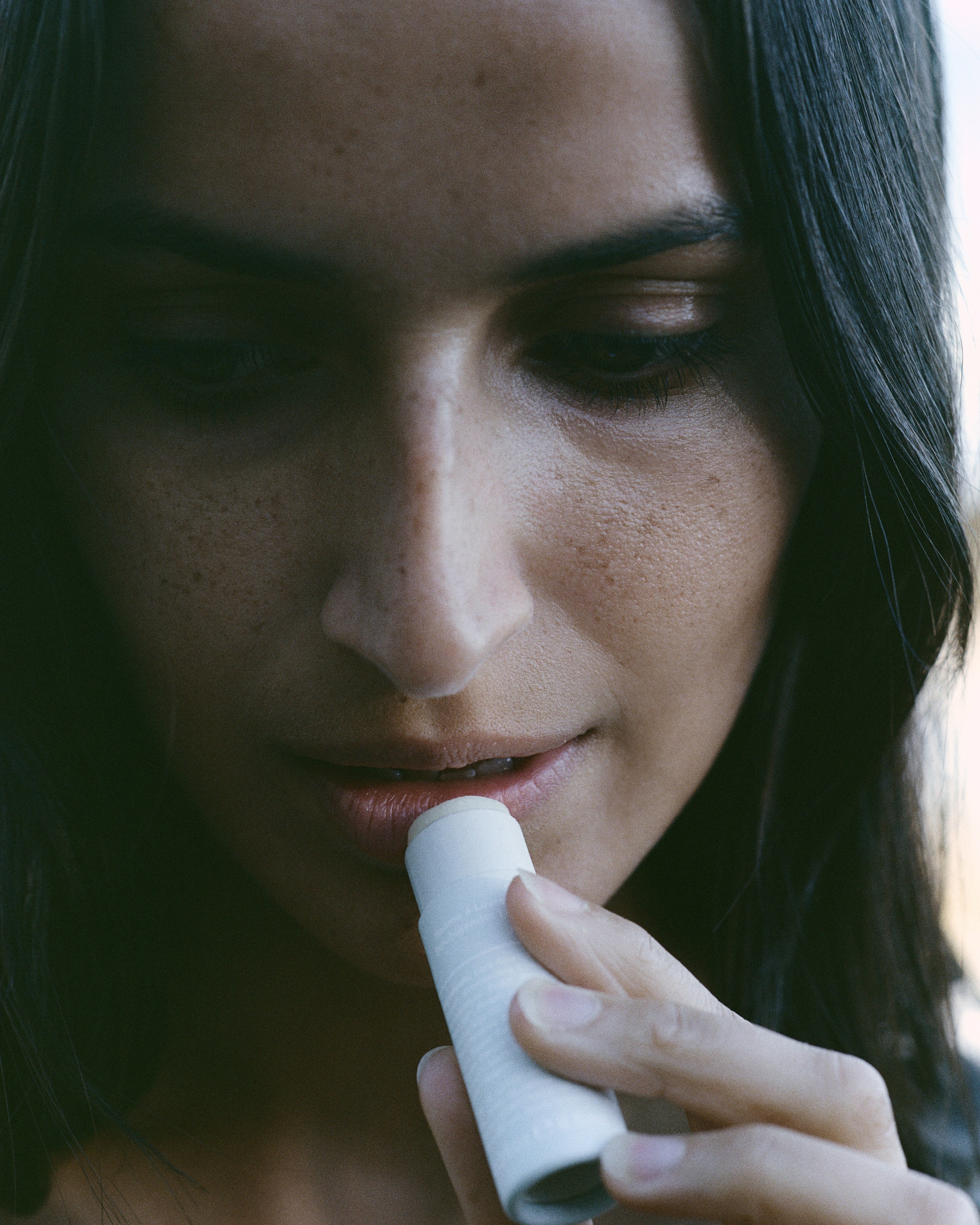 Close-up of a woman applying LESSE Lip Balm