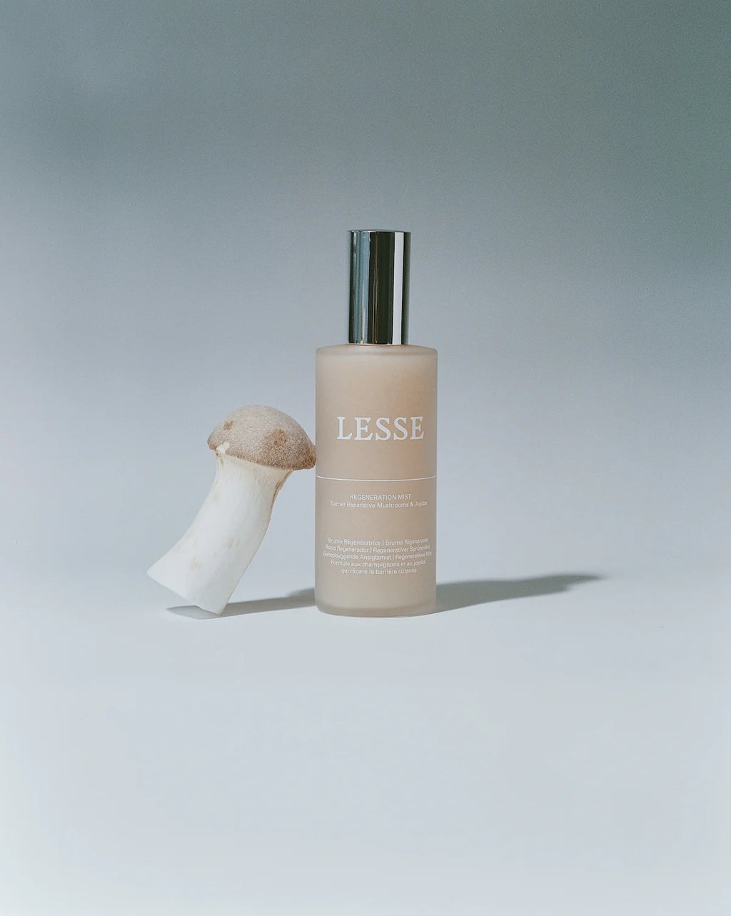 Skincare bottle labeled 'LESSE' with a mushroom-shaped object on a light gray background