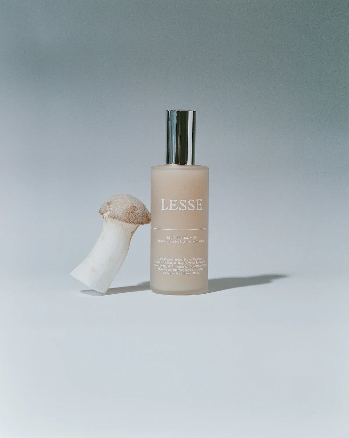 Skincare bottle labeled 'LESSE' with a mushroom-shaped object on a light gray background