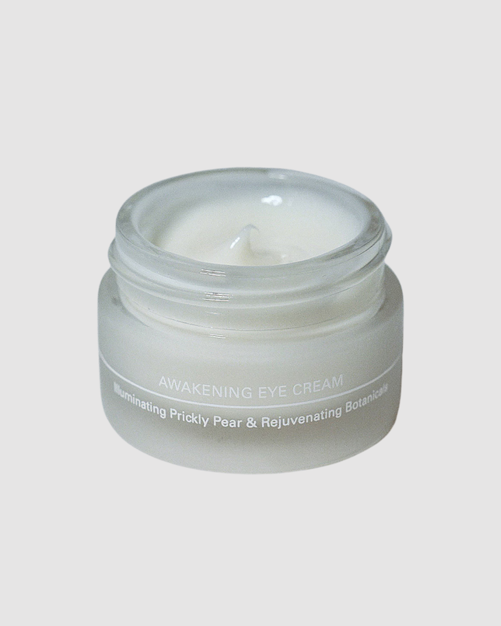 Jar of eye cream labeled 'Awakening Eye Cream' on a light gray background