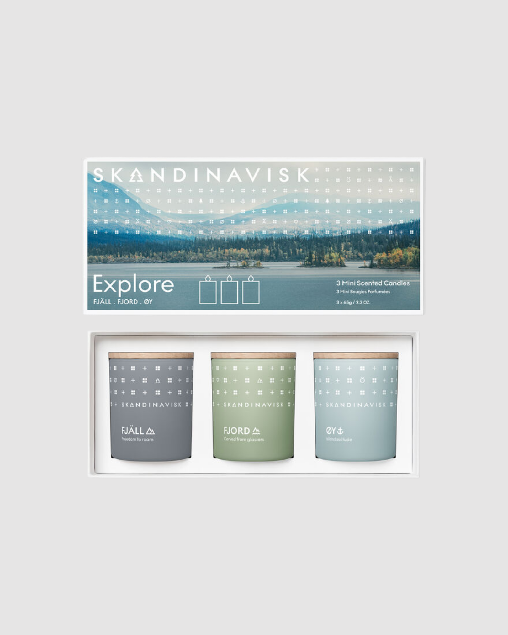 Set of three Skandinavisk candles in a decorative box with a scenic design on the lid.