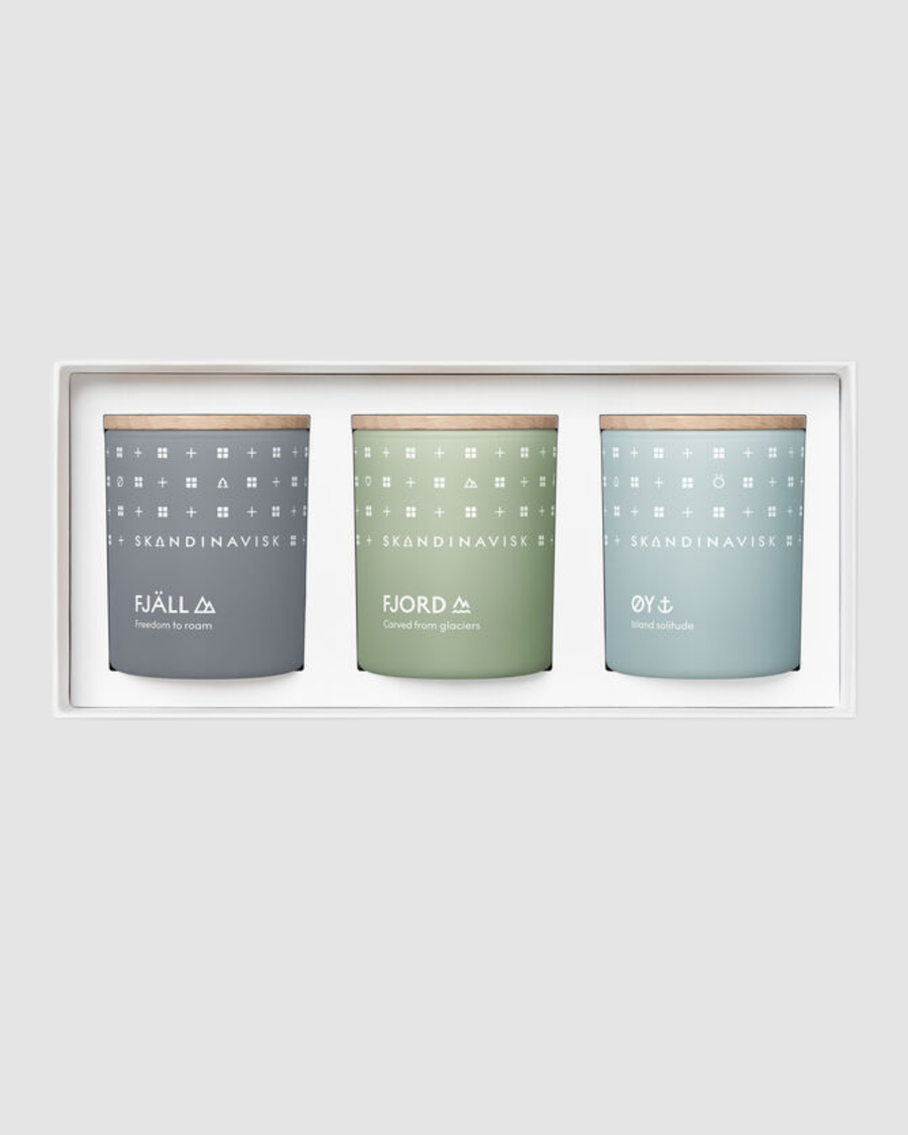 Three candles with patterned labels in a white frame on a light gray background