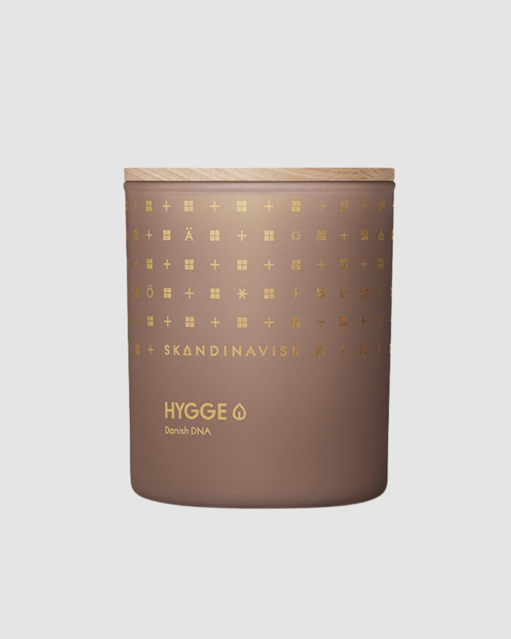 Brown candle with gold patterns and 'Skandinavisk' branding on a light gray background