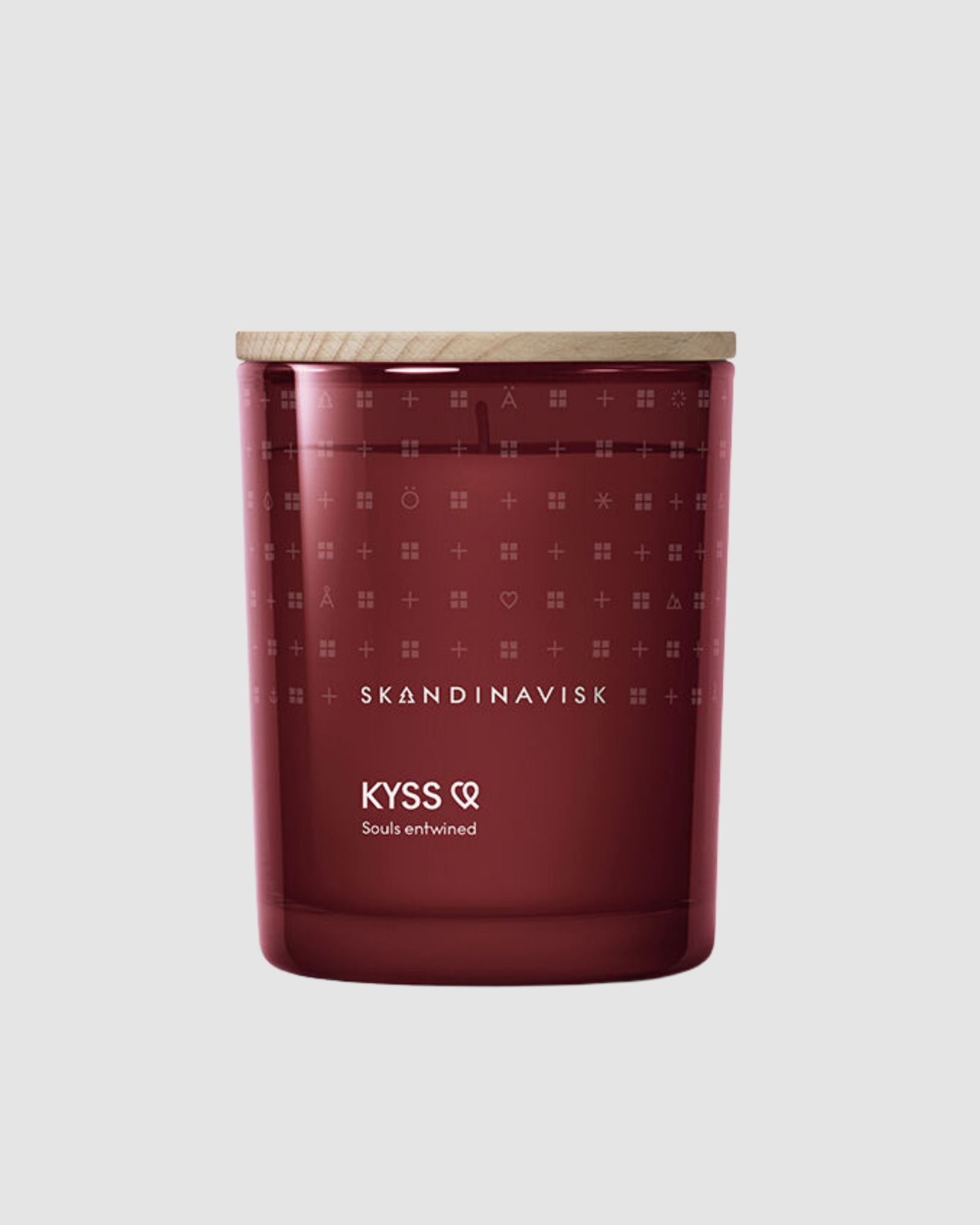 Red candle with pattern and 'Skandinavisk' branding on a light gray background